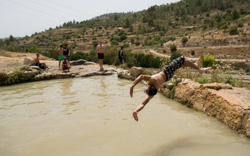 Des hommes juifs et arabes profitent d'une baignade rafraîchissante près de Jérusalem, le 27 mai 2015. (Credit photo: Yonatan Sindel / Flash90)