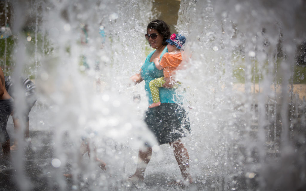 Des Israéliens jouent dans une fontaine d'eau pendant une journée exceptionnellement chaude d'été près de la Tour de David dans la Vieille Ville de Jérusalem, le 27 mai 2015  (Crédit photo: Yonatan Sindel / Flash90)