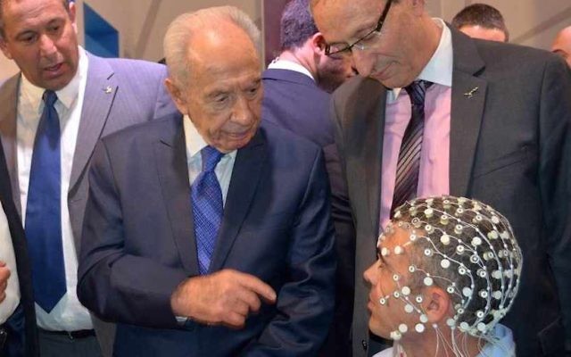 L'ancien président Shimon Peres se renseigne sur la technologie ElMindA lors de la Conférence du Président de 2013, à Jérusalem. (Crédit : Courtesy ElMindA)