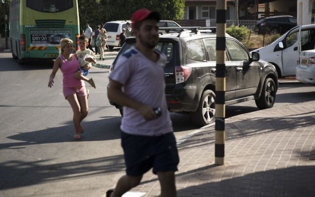 Les Israéliens se mettent à couvert dans un abri de rue tandis que l'alerte rouge sonne à Sderot, dans le sud d'Israël, le troisième jour de l'opération Bordure protectrice le jeudi 10 juillet 2014 (Crédit : Hadas Parush / Flash90) Les Israéliens se mettent à couvert dans un abri de rue tandis que l'alerte rouge sonne à Sderot, dans le sud d'Israël, le troisième jour de l'opération Bordure protectrice le jeudi 10 juillet 2014 (Crédit : Hadas Parush / Flash90)