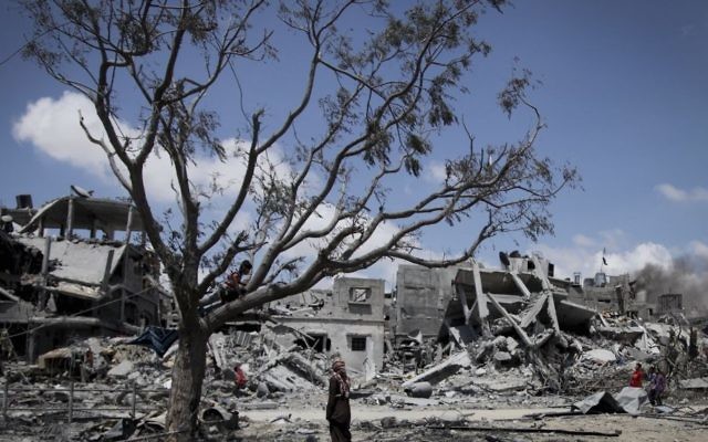 Des Palestiniens ramassent leurs effets dans les maisons détruites par les bombardements israéliens dans le nord de la bande de Gaza, à Beit Lahiya, le mardi 4 août 2014. (Crédit : Emad Nasser / Flash90)
