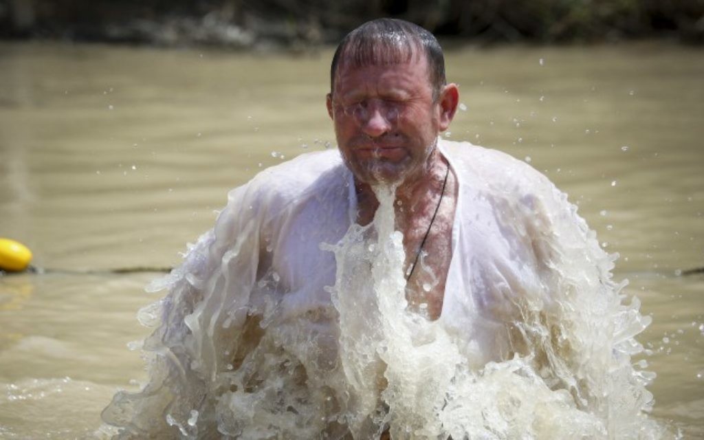 Un pèlerin chrétien orthodoxe prend un bain dans le Jourdain, dans le cadre d'une cérémonie de baptême traditionnelle sur le site de Qasr el Yahud, l'endroit où l'on pense que Jésus a été baptisé, près de la ville de Jéricho, en Cisjordanie, le 11 avril 2015. (Crédit : Maxim Dinshtein / Flash90)