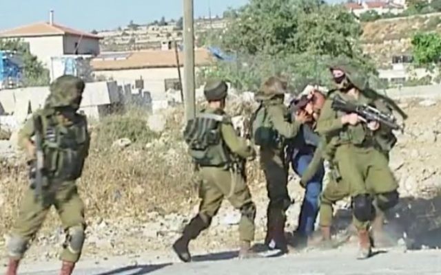 Un Palestinien battu et retenu par des soldats israéliens lors d'une manifestation violente dans le camp de réfugiés de Jelazoun, près de Ramallah, le 12 juin 2015 (Capture d'écran: Télévision palestinienne) Un Palestinien battu et retenu par des soldats israéliens lors d'une manifestation violente dans le camp de réfugiés de Jelazoun, près de Ramallah, le 12 juin 2015 (Capture d'écran: Télévision palestinienne)