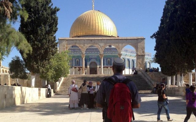 Un visiteur juif au mont du Temple regardant le Dôme du Rocher en 2013 (Crédit : Sliman Khader / Flash90, File)