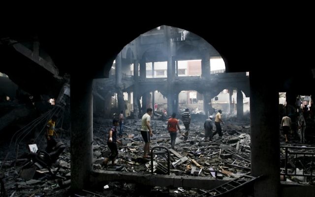 Des Palestiniens inspectent les décombres d'un centre commercial détruit après un raid aérien israélien dans la ville de Rafah, dans le sud de la bande de Gaza, le 24 août 2014 (Crédit : Abed Rahim Khatib / Flash90)