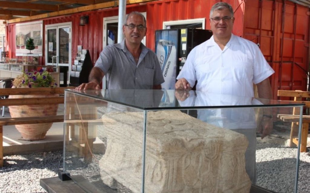 Père Juan (à droite) et l'archéologue Arfan Najjar avec la pierre de l'autel à Magdala (Crédit : Shmuel Bar-Am)