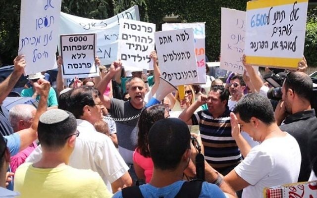 Les employés de la chaîne de supermarchés Mega manifestent devant une conférence des fournisseurs Mega à Tel Aviv le 12 juillet 2015, où Mega leur a demandé d'approuver l'accord de dette (Crédit photo: Flash90)