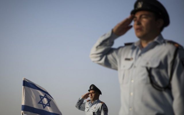 Des officiers de la police israélienne saluent les tombes des policiers décédés au cours d'une cérémonie commémorative dans la section de la police du cimetière militaire du mont Herzl à Jérusalem, le 19 avril 2015 (Crédit photo: Hadas Parush / Flash90)