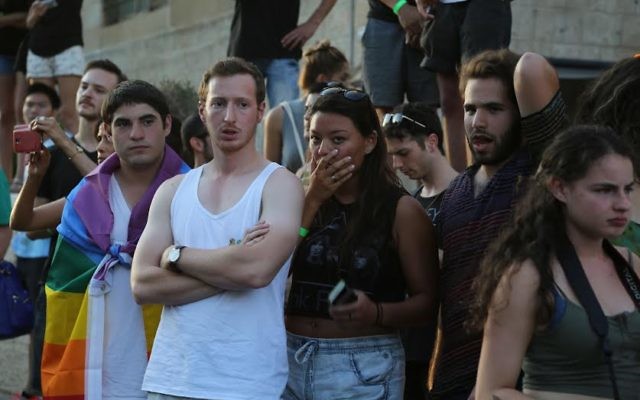Des participants à la marche de la gay pride à Jérusalem, le 30 juillet 2015, devant des participants qui ont été poignardés (Crédit : Eric Cortellessa/Times of Israel) Des participants à la marche de la gay pride à Jérusalem, le 30 juillet 2015, devant des participants qui ont été poignardés (Crédit : Eric Cortellessa/Times of Israel)