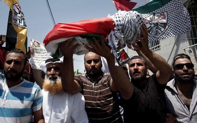 Les membre de la famille portant le corps du bébé palestinien, Ali Saad Dawabsha, décédé après que sa maison a été incendiée par des résidents juifs, lors de ses funérailles dans le village cisjordanien de Douma le 31 juillet 2015 (Crédit : AFP PHOTO / THOMAS COEX)