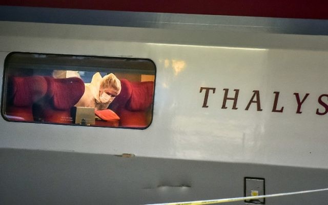 Un agent de police examine la scène du crime à l'intérieur d'un train Thalys la SNCF à la gare d'Arras, Nord de la France, le 21 août, 2015. Un homme armé a ouvert le feu dans un train blessant 3 personnes avant d'être maîtrisé par les passagers (Crédit : AFP PHOTO / PHILIPPE HUGUEN) Un agent de police examine la scène du crime à l'intérieur d'un train Thalys la SNCF à la gare d'Arras, Nord de la France, le 21 août, 2015. Un homme armé a ouvert le feu dans un train blessant 3 personnes avant d'être maîtrisé par les passagers (Crédit : AFP PHOTO / PHILIPPE HUGUEN)
