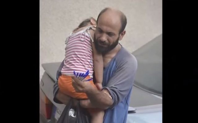 Le réfugié syrien-palestinien Adul Attar portant sa fille dans les rues de Beyrouth tout en vendant des stylos (Capture écran : YouTube) Le réfugié syrien-palestinien Adul Attar portant sa fille dans les rues de Beyrouth tout en vendant des stylos (Capture écran : YouTube)