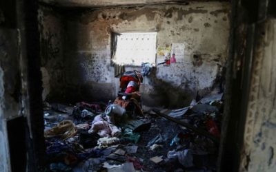 L'intérieur d'une chambre de la maison de la famille Dawabsha à Duma. Une poupée enveloppée dans un drapeau palestinien repose dans une poussette en l'honneur d'Ali (Crédit : Eric Cortellessa / Times of Israel)
