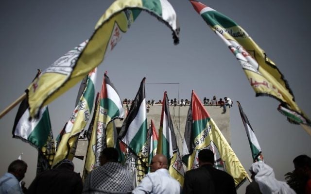 Des drapeaux palestiniens agités pendant les funérailles de Riham Dawabsha, le 7 septembre 2015 dans un cimetière du village cisjordanien de Duma. (Crédit : AFP PHOTO / THOMAS COEX)