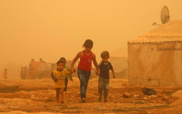 Les enfants syriens à pied au milieu de la poussière pendant une tempête de sable le 7 septembre 2015 au camp de réfugiés en périphérie de la ville libanaise de Baalbek. (Crédit : AFP PHOTO / STR) Les enfants syriens à pied au milieu de la poussière pendant une tempête de sable le 7 septembre 2015 au camp de réfugiés en périphérie de la ville libanaise de Baalbek. (Crédit : AFP PHOTO / STR)