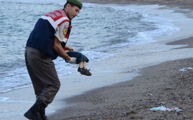 Un officier de police turc porte le cadavre d'un enfant migrant au large des côtes à Bodrum, au sud de la Turquie, le 2 septembre 2015 (Crédit : AFP / DOGAN AGENCE DE NOUVELLES) Un officier de police turc porte le cadavre d'un enfant migrant au large des côtes à Bodrum, au sud de la Turquie, le 2 septembre 2015 (Crédit : AFP / DOGAN AGENCE DE NOUVELLES)