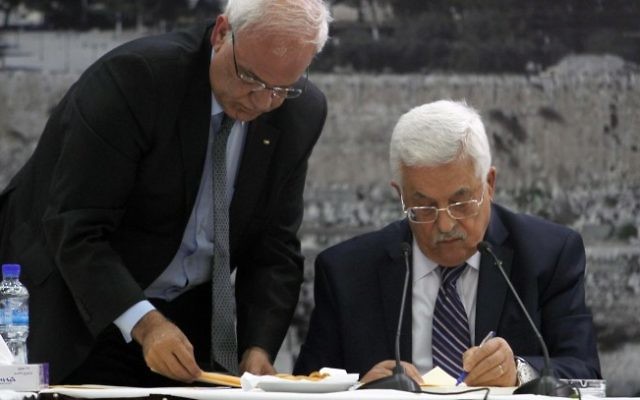 Le président de l'Autorité Mahmoud Abbas, à droite, signe une demande d'adhésion à 15 instances onusiennes et d'autres traités internationaux dans son quartier général dans la ville de Ramallah en Cisjordanie, le mardi 1er avril 2014. avec à ses côtés Saeb Erekat (Crédit : Issam Rimawi/Flash90) Le président de l'Autorité Mahmoud Abbas, à droite, signe une demande d'adhésion à 15 instances onusiennes et d'autres traités internationaux dans son quartier général dans la ville de Ramallah en Cisjordanie, le mardi 1er avril 2014. avec à ses côtés Saeb Erekat (Crédit : Issam Rimawi/Flash90)