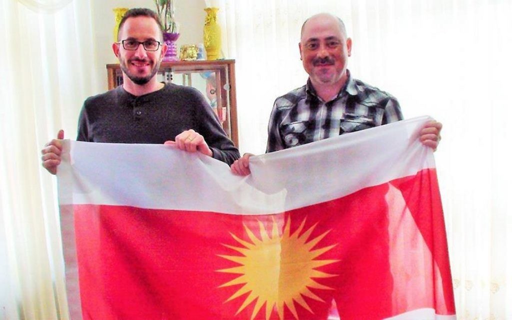 Idan Barir et un membre de la résistance yazidie tiennent un drapeau yazidi. (Crédit : Autorisation) Idan Barir et un membre de la résistance yazidie tiennent un drapeau yazidi. (Crédit : Autorisation)