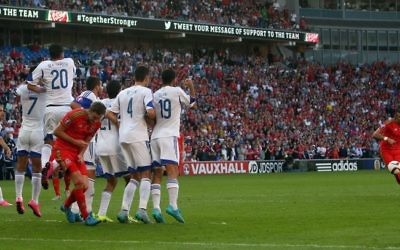 Le milieu de terrain du Pays de Galles Gareth Bale (à droite) tente un coup franc sans succès durant le match de qualification du groupe B pour l'Euro 2016 entre le Pays de Galles et Israël au Cardiff City Stadium à Cardiff, dans le sud du Pays de Galles, le 6 septembre 2015 (Crédit ; AFP / GEOFF CADDICK)