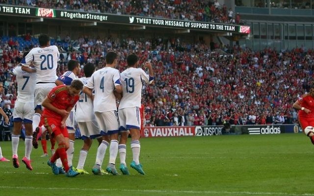 Le milieu de terrain du Pays de Galles Gareth Bale (à droite) tente un coup franc sans succès durant le match de qualification du groupe B pour l'Euro 2016 entre le Pays de Galles et Israël au Cardiff City Stadium à Cardiff, dans le sud du Pays de Galles, le 6 septembre 2015 (Crédit ; AFP / GEOFF CADDICK)