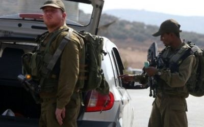 Les soldats israéliens inspectent une voiture palestinienne à un checkpoint près du village cisjordanien de Beit Furik, à l'est de Naplouse le 2 octobre 2015.. (Crédit : Jaafar Ashtiyeh/AFP)