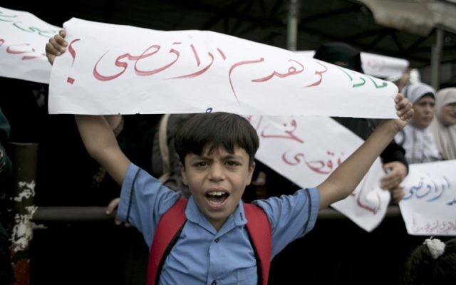 Un garçon palestinien tient une banderole en arabe qui dit : "Que faire s'ils détruisent al-Aqsa" lors d'une manifestation à Rafah, dans le sud de la bande de Gaza, le 5 octobre 2015 (Crédit : Saïd Khatib / AFP)