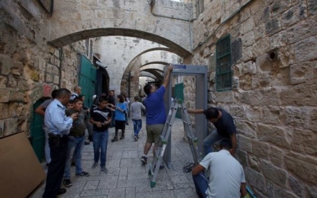Les forces de sécurité israéliennes montent la garde pendant que les travailleurs installent un détecteur de métal dans le quartier musulman de la Vieille Ville de Jérusalem le 8 octobre 2015 après une série d'attaques au couteau. (Crédit : AFP Photo / Gali Tibon)