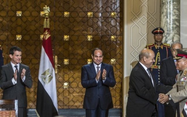 Le Premier ministre français Manuel Valls (G) et le président égyptien Abdel Fattah al-Sisi (C) applaudissent avec le ministre de la Défense français Jean-Yves Le Drian (2ndD) qui serre la main de son homologue égyptien général Sedki Sobhi (R) après la signature des contrats militaires le 10 octobre 2015 au palais présidentiel dans la capitale égyptienne du Caire. (Crédit : AFP PHOTO / KHALED DESOUKI) Le Premier ministre français Manuel Valls (G) et le président égyptien Abdel Fattah al-Sisi (C) applaudissent avec le ministre de la Défense français Jean-Yves Le Drian (2ndD) qui serre la main de son homologue égyptien général Sedki Sobhi (R) après la signature des contrats militaires le 10 octobre 2015 au palais présidentiel dans la capitale égyptienne du Caire. (Crédit : AFP PHOTO / KHALED DESOUKI)