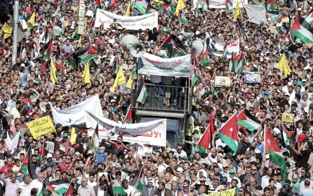Des manifestants jordaniens agitent les drapeaux jordaniens et palestiniens lors d'une manifestation près de l'ambassade d'Israël à Amman, la capitale, en solidarité avec les Palestiniens le 16 octobre 2015 (Crédit : Khalil MAZRAAWI / AFP) Des manifestants jordaniens agitent les drapeaux jordaniens et palestiniens lors d'une manifestation près de l'ambassade d'Israël à Amman, la capitale, en solidarité avec les Palestiniens le 16 octobre 2015 (Crédit : Khalil MAZRAAWI / AFP)