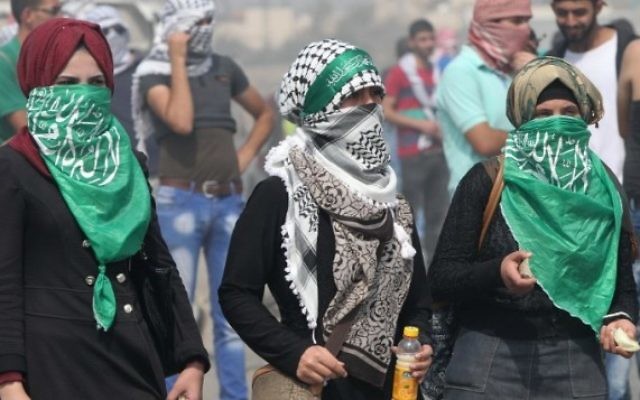 Des étudiantes palestiniennes de l'Université polytechnique de Palestine lancent des pierres sur l'implantation de Beit Hagai, à l'entrée de la ville cisjordanienne de Hébron (Crédit : AFP/ Hazem Bader) Des étudiantes palestiniennes de l'Université polytechnique de Palestine lancent des pierres sur l'implantation de Beit Hagai, à l'entrée de la ville cisjordanienne de Hébron (Crédit : AFP/ Hazem Bader)