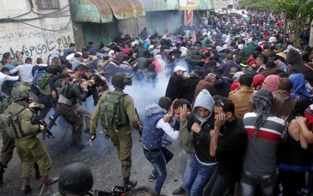 Les forces de sécurité israéliennes utilisant du gaz lacrymogène pour disperser des manifestants palestiniens lors d'une manifestation dans la ville d'Hébron en Cisjordanie le 27 octobre 2015 (Crédit photo: Hazem Bader / AFP)