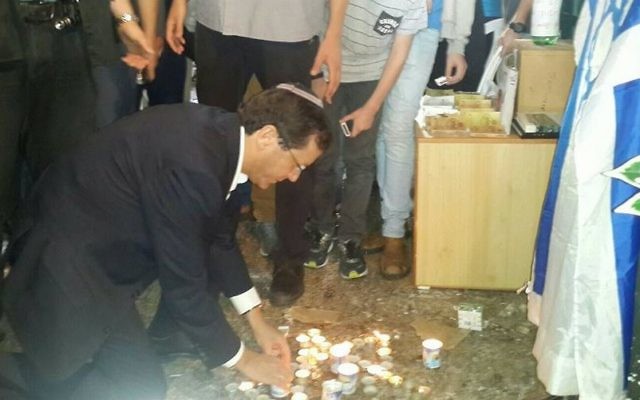 Le chef de l'opposition, Isaac Herzog, allume une bougie sur le site où Nehémia Lavi et Aharon Benett ont été poignardés à mort dans la Vieille Ville la semaine dernière. Herzog s'est rendu dans la Vieille Ville de Jérusalem, le jeudi 8 octobre 2015 (Photo: La page Facebook d'Isaac Herzog)