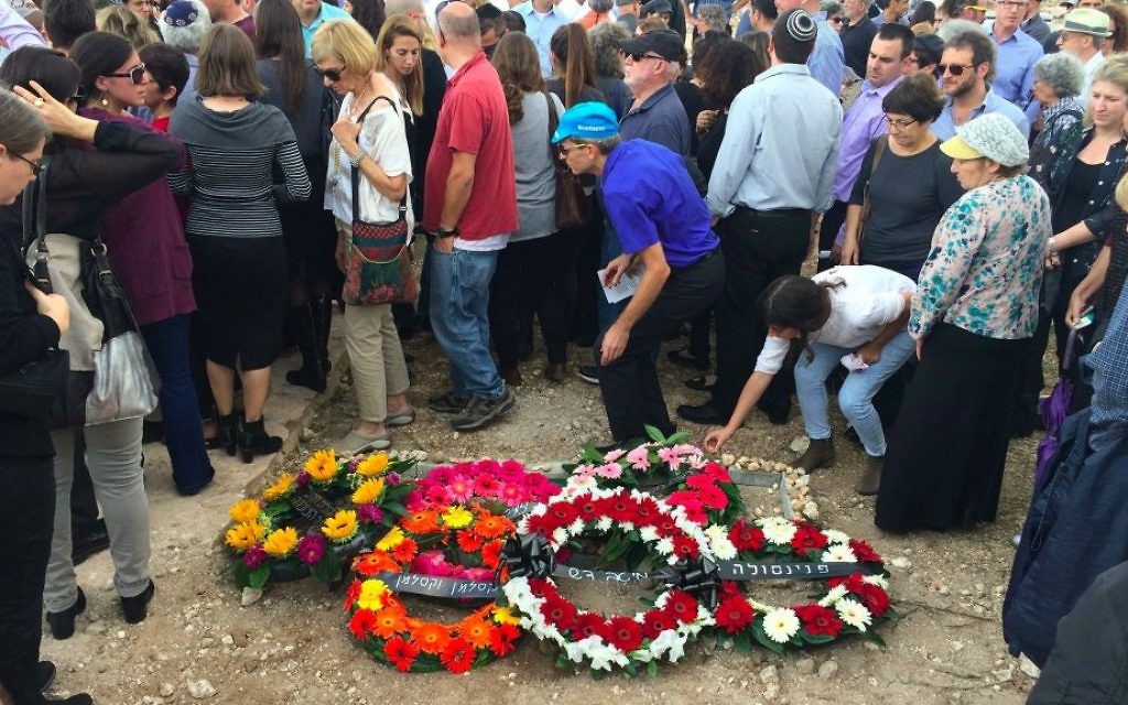 Des personnes en deuil posant des pierres sur la tombe de la victime du terrorisme Richard Lakin, le 28 octobre 2015 (Crédit : Renee Ghert-Zand / TOI)