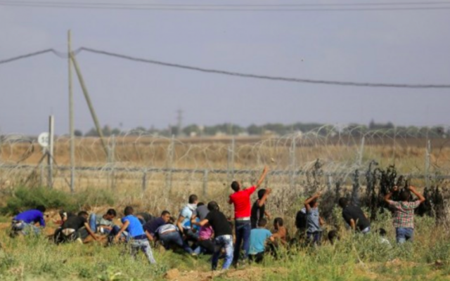 Des Gazaouis s'approchent de la clôture de la frontière avec Israël lors d'affrontements avec les soldats de Tsahal, le 9 octobre 2015. (Crédit photo: Mohammed Abed / AFP) Des Gazaouis s'approchent de la clôture de la frontière avec Israël lors d'affrontements avec les soldats de Tsahal, le 9 octobre 2015. (Crédit photo: Mohammed Abed / AFP)