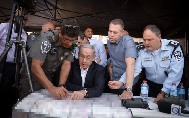 Benjamin Netanyahu, au centre, avec le ministre de la Sécurité publique Gilad Erdan, deuxième à droite, et les fonctionnaires de police lors d'une tournée à Jérusalem-Est le 16 septembre 2015 (Crédit : Amos Ben Gershom / GPO) Benjamin Netanyahu, au centre, avec le ministre de la Sécurité publique Gilad Erdan, deuxième à droite, et les fonctionnaires de police lors d'une tournée à Jérusalem-Est le 16 septembre 2015 (Crédit : Amos Ben Gershom / GPO)