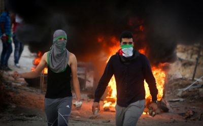 Des manifestants palestiniens jettent des pierres et brûlent des pneus lors d'affrontements avec les forces de sécurité israéliennes près du checkpoint de Hizma, en Cisjordanie, le 30 septembre 2015. Illustration. (Crédit : Flash90) Des manifestants palestiniens jettent des pierres et brûlent des pneus lors d'affrontements avec les forces de sécurité israéliennes près du checkpoint de Hizma, en Cisjordanie, le 30 septembre 2015. Illustration. (Crédit : Flash90)