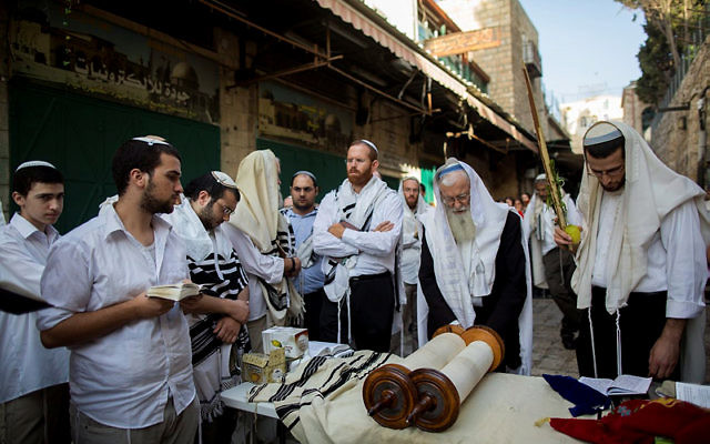 Des hommes prient sur le lieu de l'attaque où deux Israéliens ont ét tués par un terroriste palestinien la veille (Crédit : Flash 90) Des hommes prient sur le lieu de l'attaque où deux Israéliens ont ét tués par un terroriste palestinien la veille (Crédit : Flash 90)