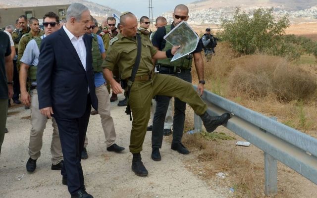 Le Premier ministre israélien Benjamin Netanyahu (g) visite la Cisjordanie le 6 octobre 2015, à la suite des récentes attaques terroristes. (Crédit : Amos Ben Gershom / GPO)