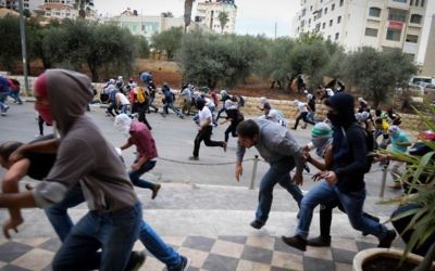 Des émeutiers palestiniens lançant des pierres pendant des affrontement avec les troupes israéliennes à Bet El, près de la ville cisjordanienne de Ramallah, le 10 octobre 2015 (Flash90) Des émeutiers palestiniens lançant des pierres pendant des affrontement avec les troupes israéliennes à Bet El, près de la ville cisjordanienne de Ramallah, le 10 octobre 2015 (Flash90)
