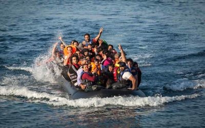 Un canot transportant des réfugiés débarque sur une plage de l'île de Lesbos au nord de la Grèce (Crédit : Boaz Arad/IsraAID)
