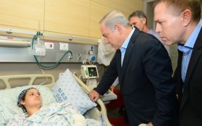 Le Premier ministre Benjamin Netanyahu et le ministre de la Sécurité intérieure rendent visite à Adèle Benet et à son bébé, qui ont été blessés  le 3 octobre 2015 dans un attentat terroriste dans la Vieille Ville de Jérusalem au cours duquel Aharon Benet a été assassiné, à l'hôpital Hadassah Ein Kerem à Jérusalem, le 5 octobre 2015 (Crédit : Kobi Gideon / GPO)
