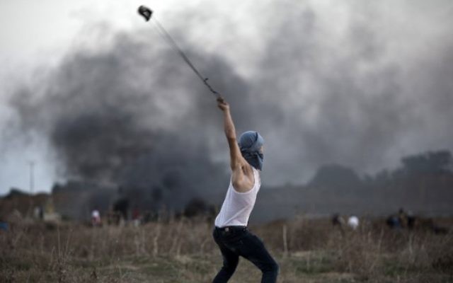 Un émeutier palestinien utilise un lance-pierre pour jeter des pierres sur des soldats israéliens lors d'affrontements, près de la barrière de sécurité entre Israël et la bande de Gaza, le 15 octobre 2015. Illustration. (Crédit : Mohammed Abed/AFP) Un émeutier palestinien utilise un lance-pierre pour jeter des pierres sur des soldats israéliens lors d'affrontements, près de la barrière de sécurité entre Israël et la bande de Gaza, le 15 octobre 2015. Illustration. (Crédit : Mohammed Abed/AFP)