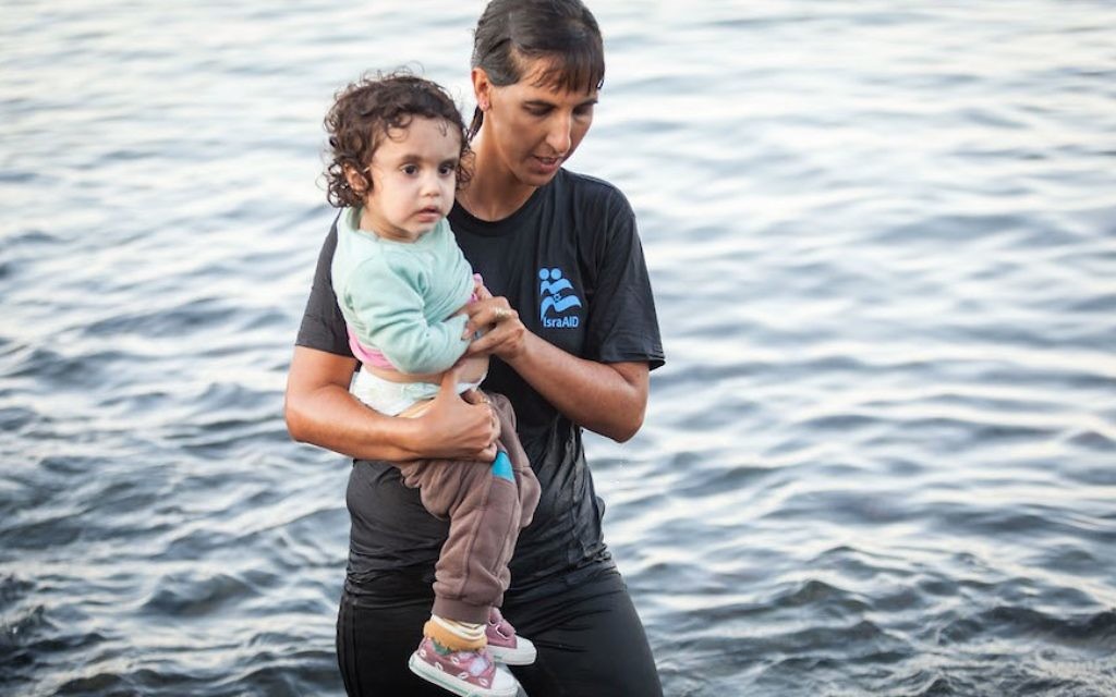Tali Shaltiel, 31 ans, médecin à Jérusalem, de l'eau jusqu'aux genoux, aide une petite fille de quatre ans (Crédit : JTA) Tali Shaltiel, 31 ans, médecin à Jérusalem, de l'eau jusqu'aux genoux, aide une petite fille de quatre ans (Crédit : JTA)
