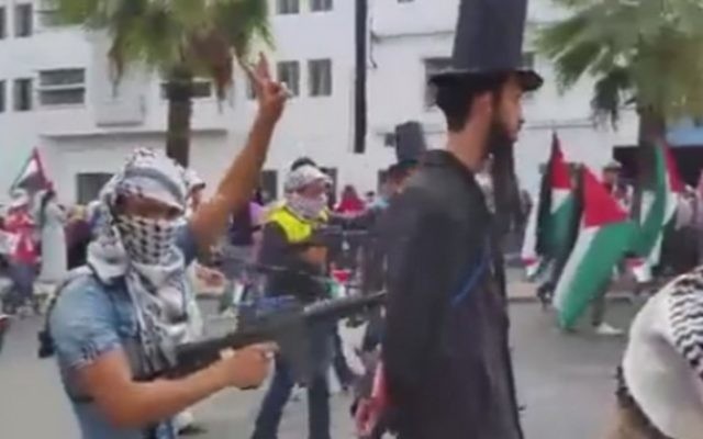 Manifestation pro-palestinienne à Casablanca, au Maroc, dans laquelle "des Juifs" sont tenus à la pointe d'une mitraillette par des manifestants vêtus de keffiehs, le 25 octobre 2015 (Capture d'écran: alyaexpress-news.com) Manifestation pro-palestinienne à Casablanca, au Maroc, dans laquelle "des Juifs" sont tenus à la pointe d'une mitraillette par des manifestants vêtus de keffiehs, le 25 octobre 2015 (Capture d'écran: alyaexpress-news.com)