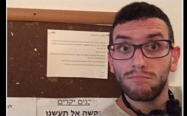 Un résident arabe de Tel-Aviv prend un selfie devant une notice anti-arabe accrochée dans la cage d'escalier de son immeuble le 12 octobre 2015 (Crédit : Capture d'écran Facebook)