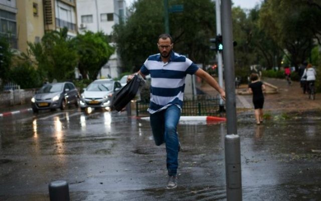 Un homme saute par-dessus une flaque d'eau alors qu'une tempête s'abat sur Tel Aviv, le 25 octobre 2015 (Crédit photo: Ben Kelmer / Flash90) Un homme saute par-dessus une flaque d'eau alors qu'une tempête s'abat sur Tel Aviv, le 25 octobre 2015 (Crédit photo: Ben Kelmer / Flash90)