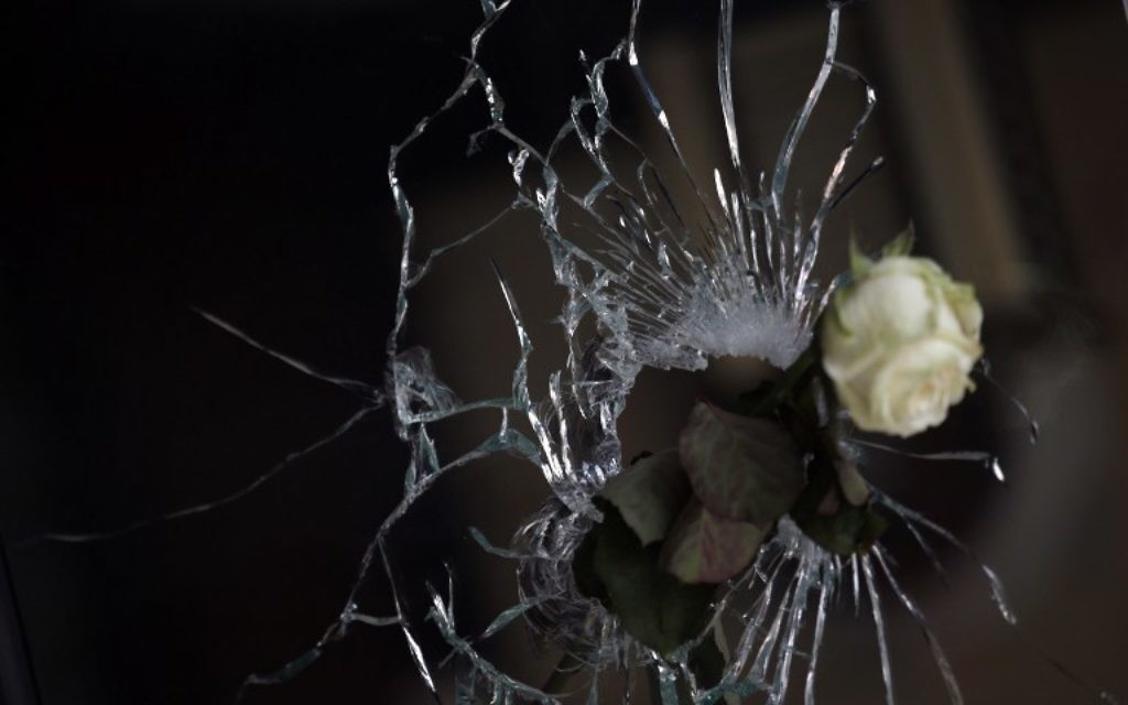 Une rose est posée dans un impact de balle dans la fenêtre d'un restaurant japonais à côté du café 'La Belle Equipe ", rue de Charonne, le 15 novembre 2015 à Paris, (Crédit : AFP PHOTO / KENZO TRIBOUILLARD)