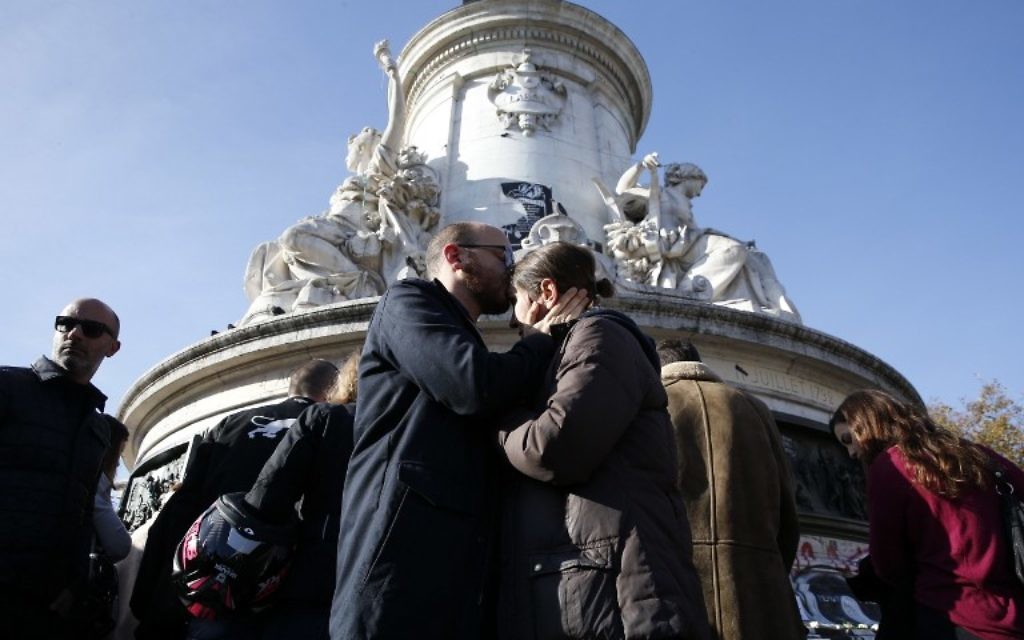 Des gens se réconfortent sur la place de la République le 15 novembre 2015 (crédit : AFP)