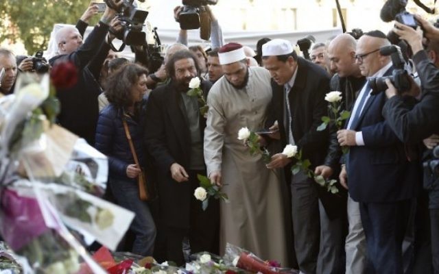 L'auteur français Marek Halter (4e à gauche), l'imam de la mosquée de Drancy, Hassen Chalghoumi (6e à gauche), les représentants des communautés juives et musulmanes et autres se réunissent à un mémorial de fortune près de la salle de concert au Bataclan à Paris le 15 novembre, 2015, deux jours après une série d'attaques meurtrières. (Crédit : AFP / Miguel Medina) L'auteur français Marek Halter (4e à gauche), l'imam de la mosquée de Drancy, Hassen Chalghoumi (6e à gauche), les représentants des communautés juives et musulmanes et autres se réunissent à un mémorial de fortune près de la salle de concert au Bataclan à Paris le 15 novembre, 2015, deux jours après une série d'attaques meurtrières. (Crédit : AFP / Miguel Medina)