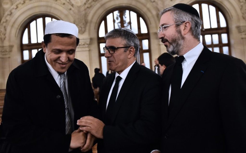 Le rabbin Moshe Sebbag (d) et l'imam de la mosquée de Drancy, Hassan Chalghoumi (g) arrivent à la Grande synagogue de la Victoire avant de rendre hommage aux victimes d'une série d'attaques meurtrières, le 15 novembre 2015. (Crédit : AFP PHOTO / LOIC VENANCE)